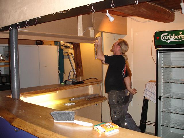 DSC01496.JPG - Overbygningen skal også dækkes af indvendig, så det er Stig igang med. Læg mærke til at formanden næsten kan gemme sig bag Stig.